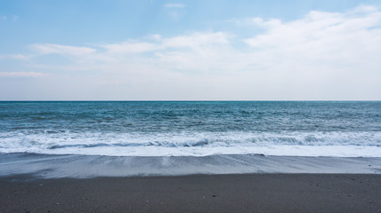 Fototapeta na wymiar Volcanic Black Sand Beach and Blue Ionian Sea in Sicily