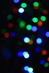 Colored lights (garland) in the dark. Bokeh effect Festive illumination.