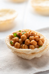 Vegan snack on a light background. Chickpeas with parsley and airy crisp bread.