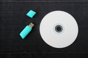 cd or dvd, flash drive on black background