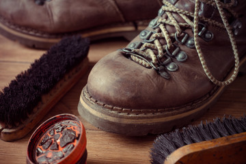 Fototapeta na wymiar Old vintage leather boots with shoe brush on wooden background
