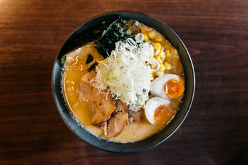 Top view of Ramen Pork Bone Soup (Tonkotsu Ramen) with Chashu Pork, Scallion, Sprout, Corn, Dried Seaweed and boiled eggs.
