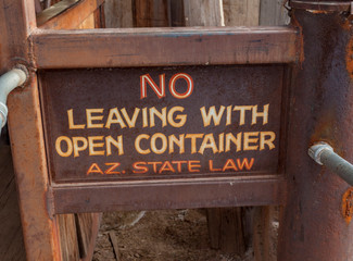 Rusty NO LEAVING WITH OPEN CONTAINER sign. Arizona law.