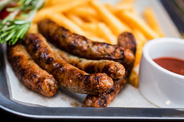 Close up meal with sausages, french fries, chili pepper and jalapeno