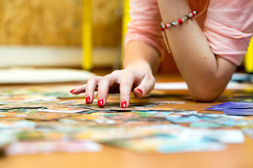 A woman's hand with red nails sorting pictures
