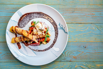 Top view delicious dessert with waffle rolls, ice cream and strawberries