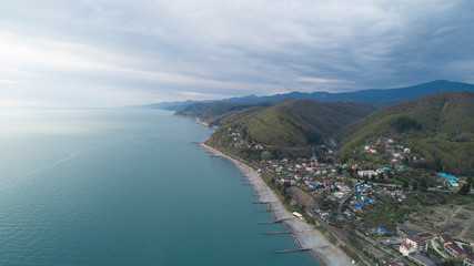 Beautiful aerial view of a coastal settlement at evening. Golovinka, Sochi. view of the highest bridge in Russia. serpentine in the mountains 