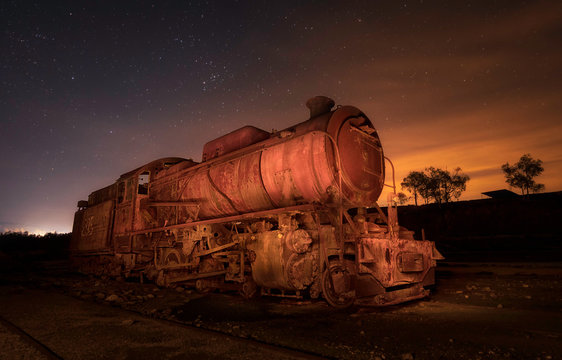 Old deserted retro train on rails between field and heaven with stars in evening in Rio Tinto, Spain