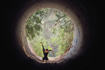 Young ballerina dancing in forest