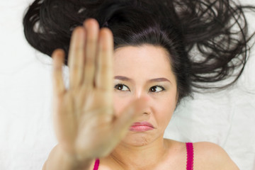 Naklejka premium Closeup portrait of moody asian women lying on ground with black long hair. acting upset , unhappy,