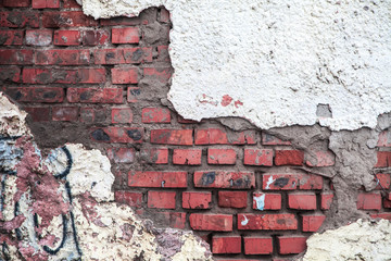 brick wall with sprinkled plaster. fragments of plaster resemble the shape of the continents of the globe.