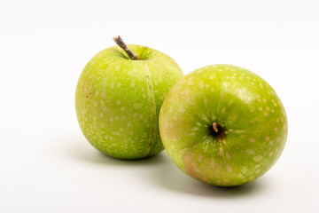 Two green ripe apple close up on a white background