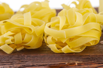Wide cooking noodles on a wooden base