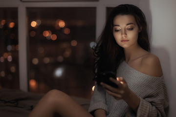 Woman use of mobile phone indoors at night