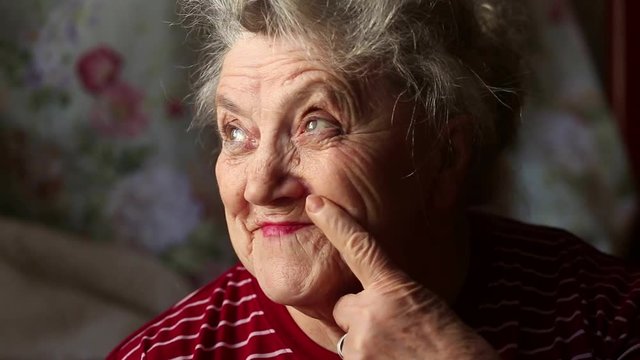 Elderly woman smile and nose picking