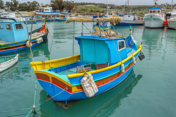 Fototapeta na wymiar Colorful fishing boats moor in Marsaxlokk, Malta
