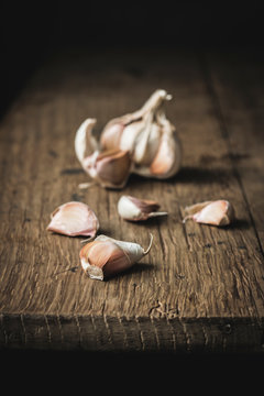 Closeup unpeeled garlic on rough wooden table