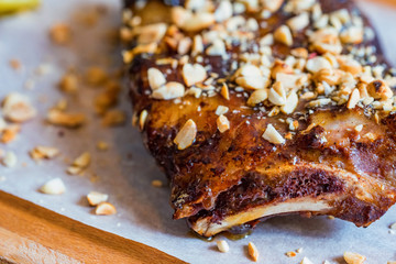 Close up board with pork ribs grilled with BBQ sauce and peanuts