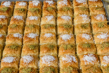 Close up of traditional oriental sweet pastry cookies known as backlava, Turkish desert with sugar, honey and pistachio,  in display at a street food market, top view