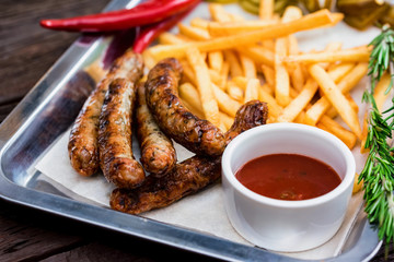 Top view meal with sausages, french fries, chili pepper and jalapeno