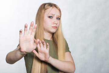 Young sad woman raising palms in no or stop gesture, wanting to decline offer.