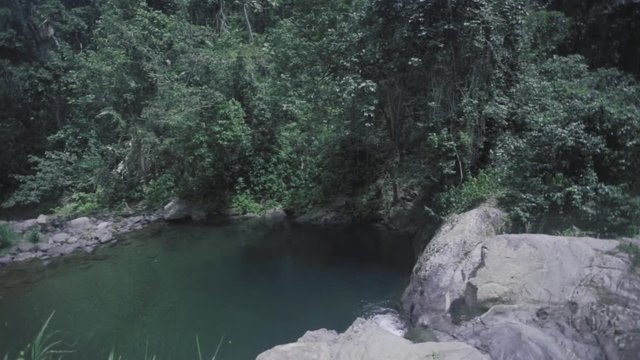 SLOW MOTION: pushing over a rock and tilting down to reveal more of Mango Waterfall in Adjuntas, Puerto Rico.
