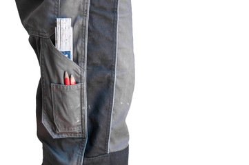 side view of waist-high Builder in work clothes in pocket pencils and ruler on white background