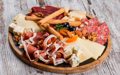Antipasto platter cold meat with grissini bread sticks, prosciutto, slices ham, beef jerky, salami...