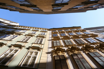 City of Vienna, capital of Austria with view looking up in a narrow street in the old quarter of district one showing typical imperial architecture in sun and blue sky