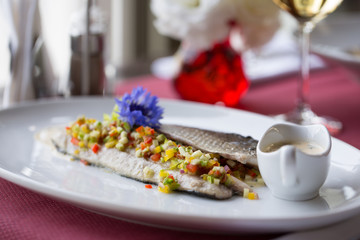 baked fish with vegetables and sauce in restaurant