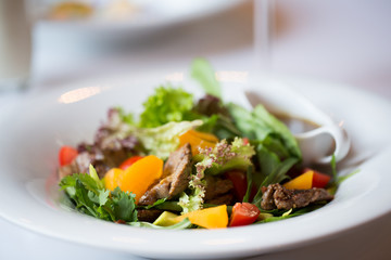 salad with beef, vegetables and sauce. Dinner in restaurant