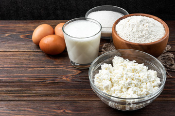 Ingredients for preparation cottage cheese pancakes. Cottage cheese, eggs, milk, sugar and flour. 