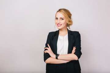 Joyful confident blonde businesswoman in suit smiling to camera isolated on white background....