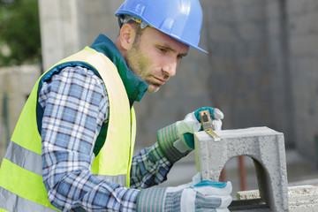 male builder working with cement block