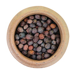 Dried medicinal herbs raw materials isolated on white. Fruit of Crataegus commonly called hawthorn, thornapple, May-tree, whitethorn, or hawberry. Cure for the heart. medicine in a cup of tea.