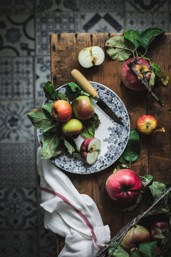From above plate with apples and knife on wooden rustic table