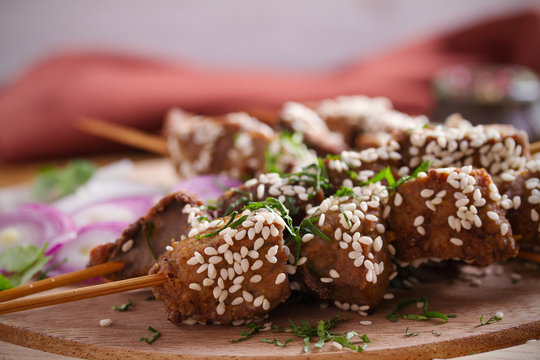 Beef liver on skewers with sesame seeds on wooden tray. Liver Kebab, kabob - image