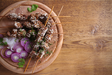 Beef liver on skewers with sesame seeds on wooden tray. Liver Kebab, kabob. room for text
