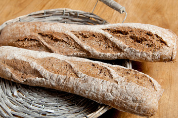 Fresh bread in a basket on a brown background
