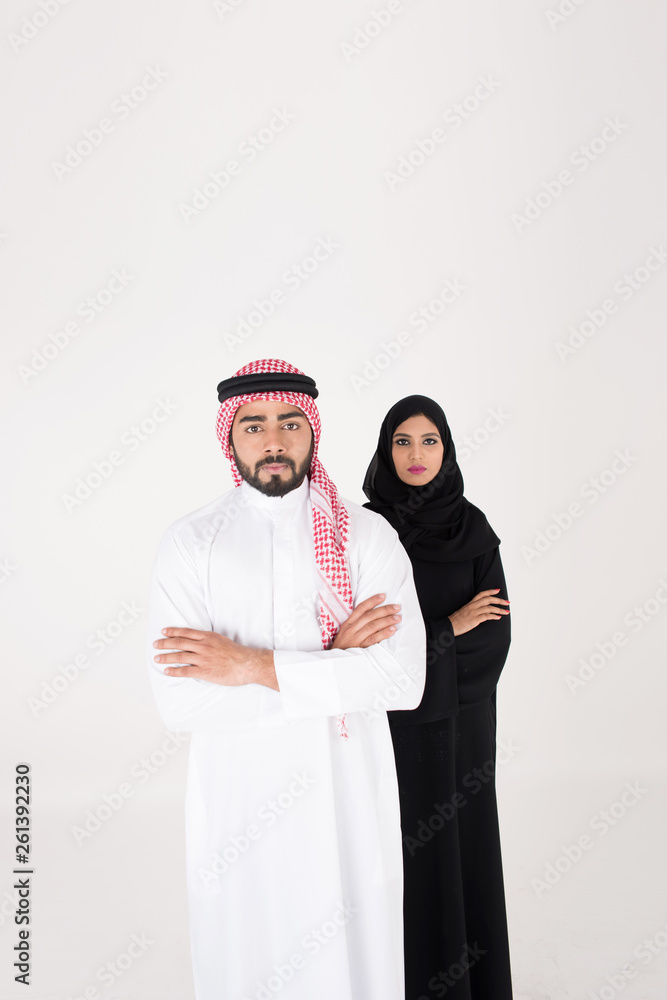 Wall mural arab couple smiling and standing on white background