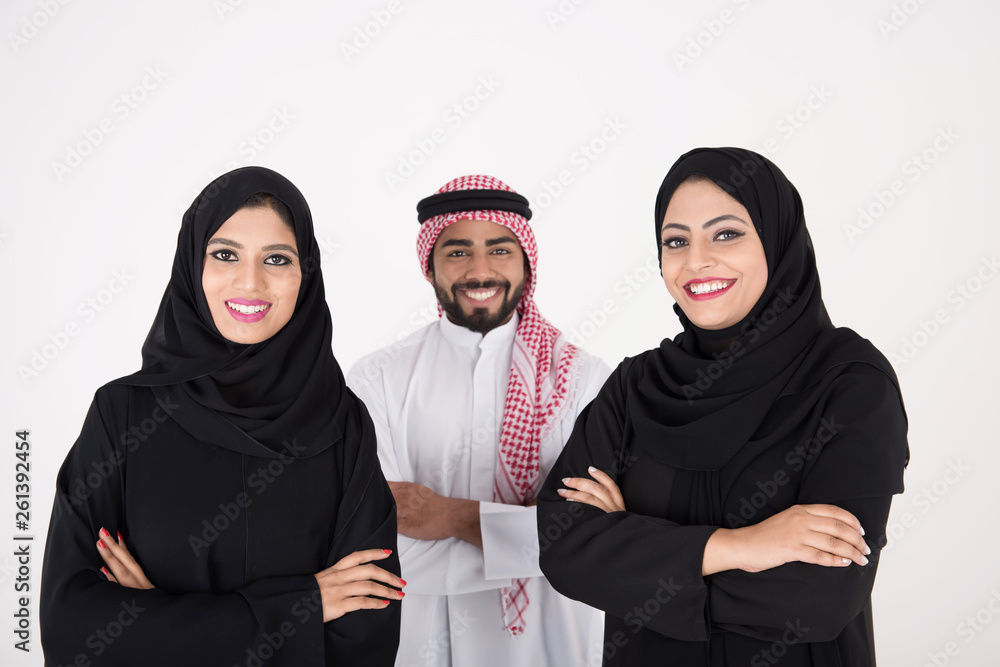 Wall mural two arab females with one male smiling and standing on white background