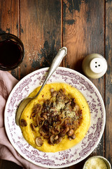 Polenta with fried mushrooms, parmesan cheese and caramelized onion.Top view with copy space.