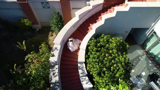 Aerial drone view of a brida walking down stairs on her wedding day