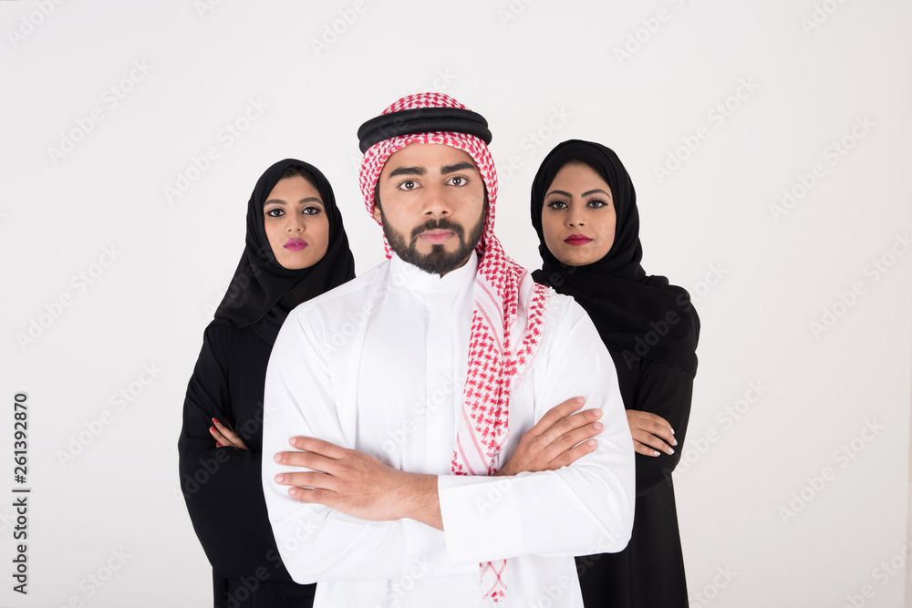 Wall mural two arab females with one male smiling and standing on white background