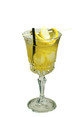 yellow alcohol drink with ice, black straw and lemon slices in high stem glass isolated on white
