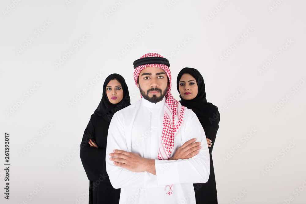 Wall mural two arab females with one male smiling and standing on white background