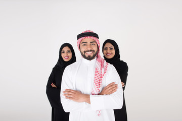 Two arab females with one male smiling and standing on white background