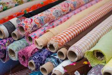 many fabric rolls and colorful textiles at market