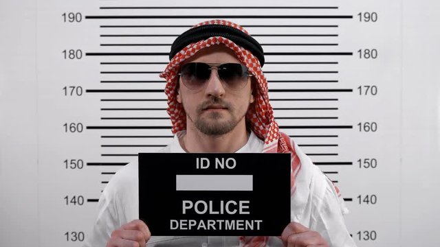 Mugshot of an Arab wearing glasses at the police station 4K