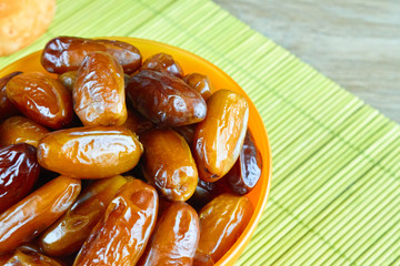 sweet algerian arabic dates fruits on an orange plate